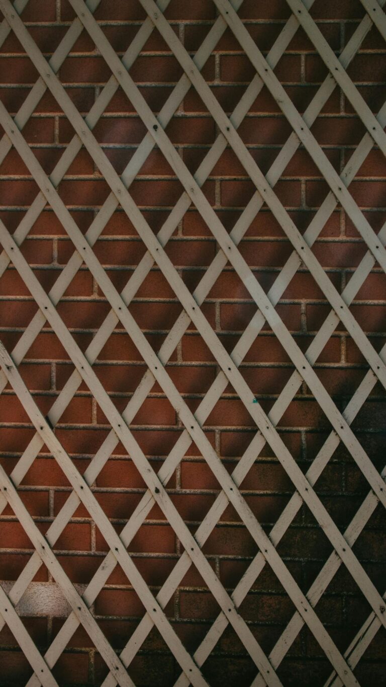 Image of a wooden lattice pattern on a red brick wall, perfect for texture and design inspiration.