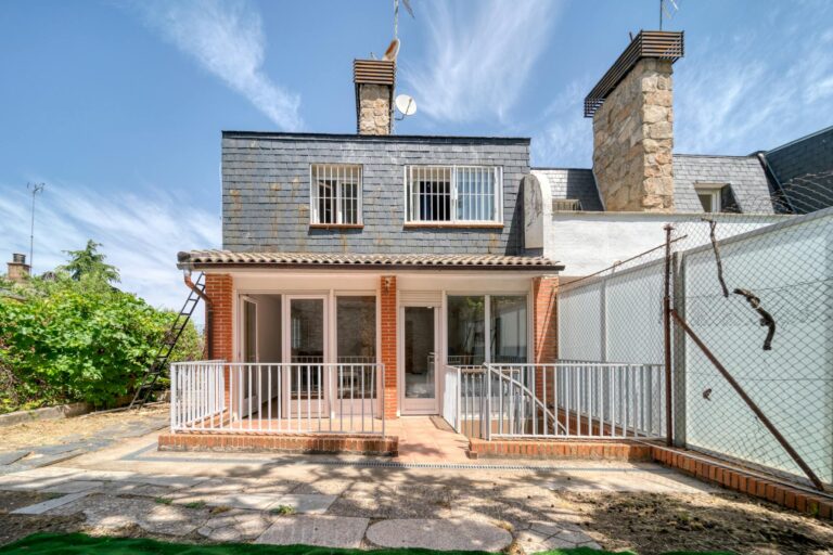 Stylish brick house exterior featuring a spacious patio and large windows on a sunny day.